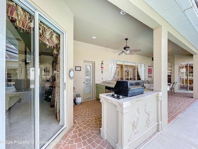 view of patio featuring ceiling fan, sink, and grilling area