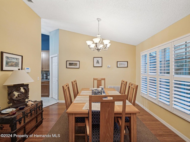 92 Randolph Ave, Spring Hill, FL 34606 - dining area with dark wood finished floors, a chandelier, and a textured ceiling