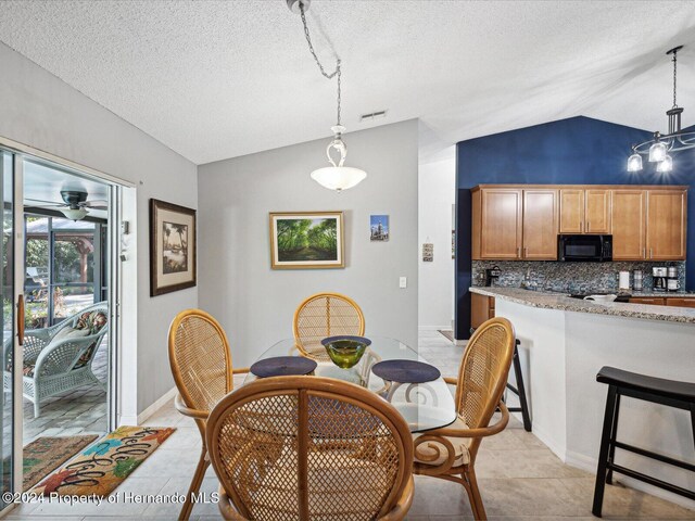 92 Randolph Ave, Spring Hill, FL 34606 - dining room with vaulted ceiling, a textured ceiling, ceiling fan, and light tile patterned floors