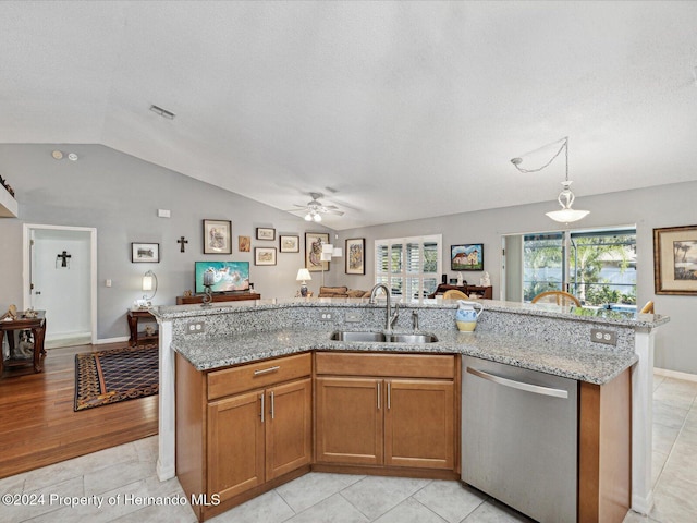 kitchen featuring sink, stainless steel dishwasher, an island with sink, vaulted ceiling, and light wood-type flooring