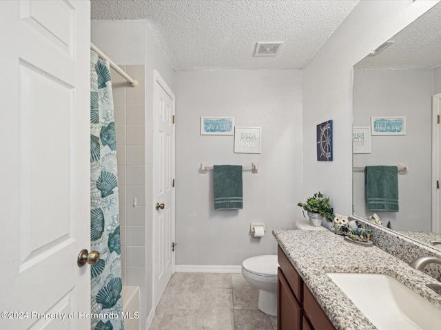 bathroom featuring tile patterned floors, vanity, toilet, and a textured ceiling