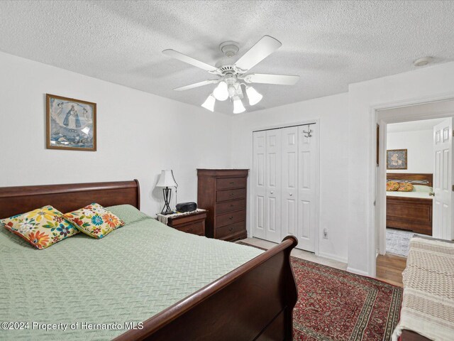 92 Randolph Ave, Spring Hill, FL 34606 - bedroom with a textured ceiling, a closet, and a ceiling fan