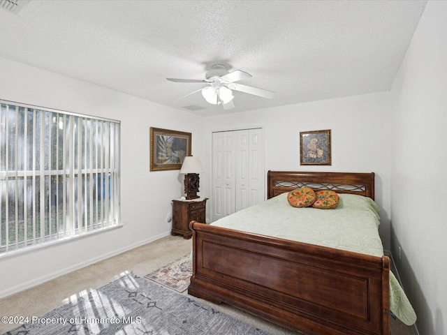 92 Randolph Ave, Spring Hill, FL 34606 - bedroom featuring a closet, light carpet, ceiling fan, and a textured ceiling