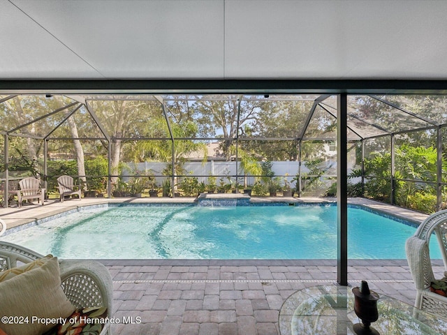 view of pool featuring pool water feature, a lanai, and a patio area