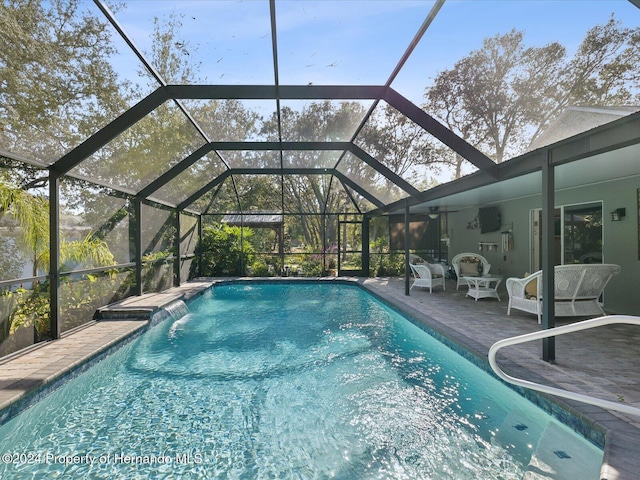 view of swimming pool with a lanai, ceiling fan, and a patio