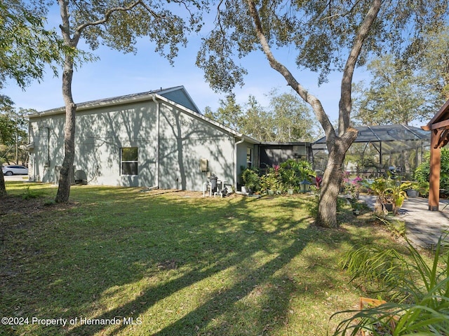 exterior space featuring a lawn and glass enclosure