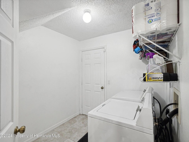 laundry room with independent washer and dryer and a textured ceiling