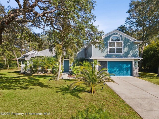 92 Randolph Ave, Spring Hill, FL 34606 - obstructed view of property featuring a garage, driveway, a front yard, and stucco siding