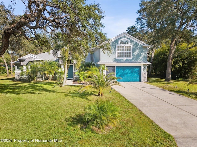 92 Randolph Ave, Spring Hill, FL 34606 - obstructed view of property featuring a garage, concrete driveway, a front yard, stone siding, and stucco siding