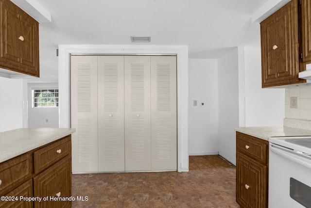 kitchen with white range with electric stovetop, backsplash, and custom exhaust hood