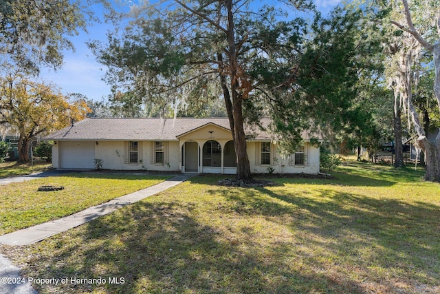 ranch-style home featuring a front lawn, a porch, and a garage