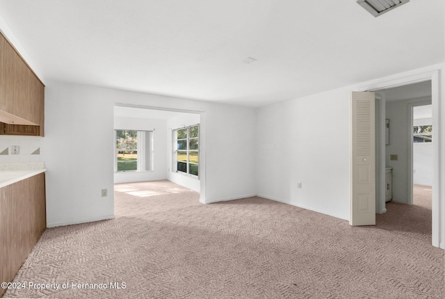 unfurnished living room featuring light carpet