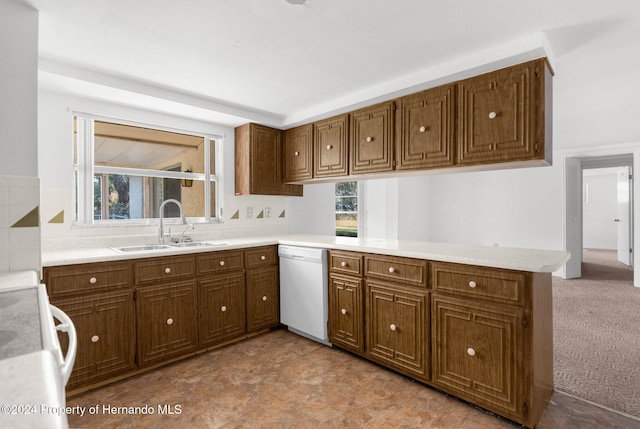 kitchen with sink, kitchen peninsula, white dishwasher, light colored carpet, and range