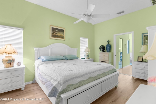 bedroom featuring ceiling fan, light wood-type flooring, and multiple windows