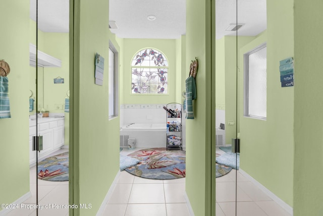 hallway featuring a textured ceiling and light tile patterned flooring