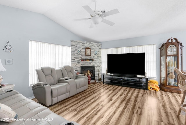 living room featuring a fireplace, light wood-type flooring, ceiling fan, and lofted ceiling