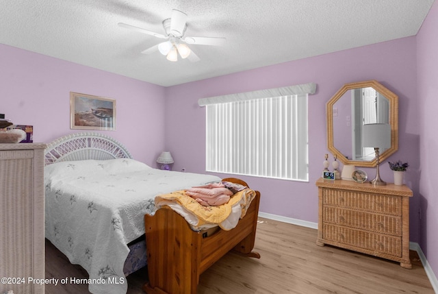 bedroom featuring ceiling fan, a textured ceiling, and light wood-type flooring