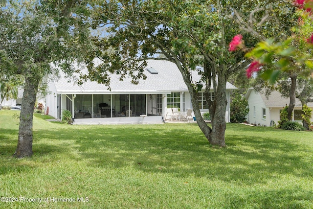 back of house featuring a sunroom and a yard