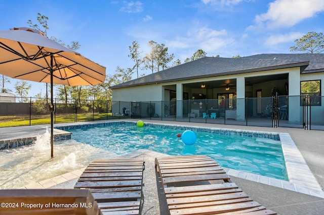 view of swimming pool with pool water feature and a patio area