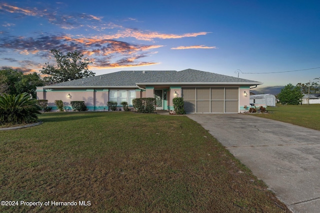 single story home with a garage and a lawn