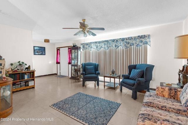 tiled living room with ceiling fan and a textured ceiling