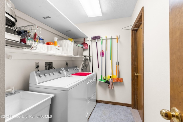 clothes washing area with separate washer and dryer and sink