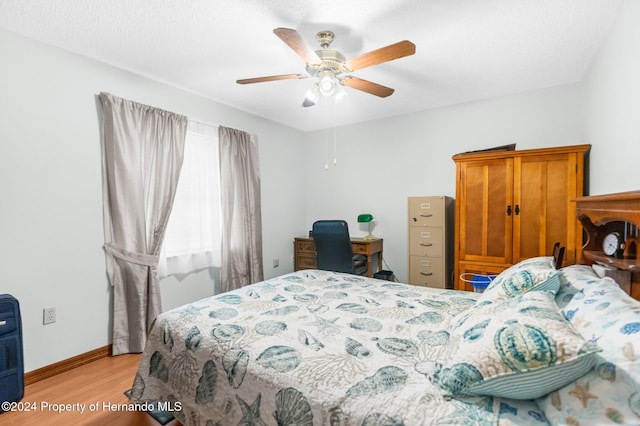 bedroom with light hardwood / wood-style flooring and ceiling fan