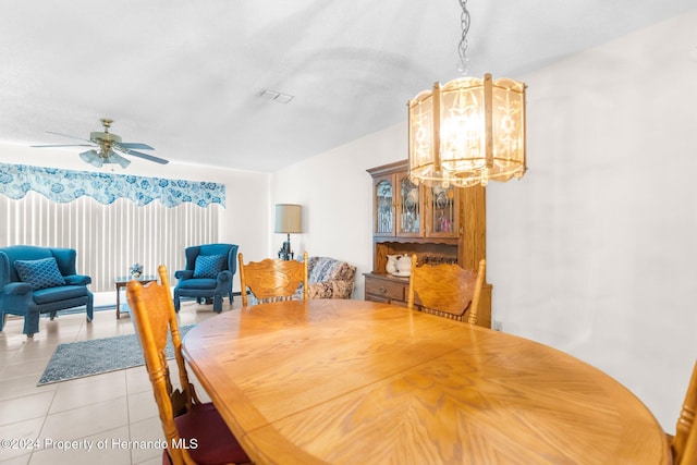 tiled dining space featuring ceiling fan with notable chandelier