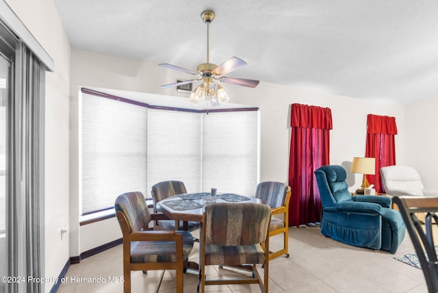 dining space featuring a textured ceiling, ceiling fan, and light tile patterned flooring