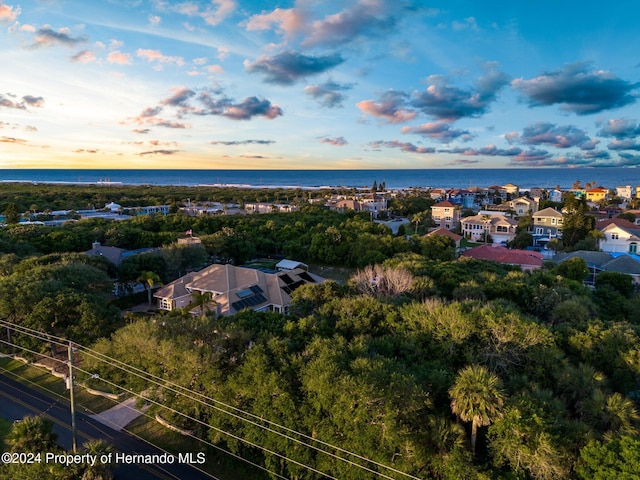 aerial view at dusk featuring a water view