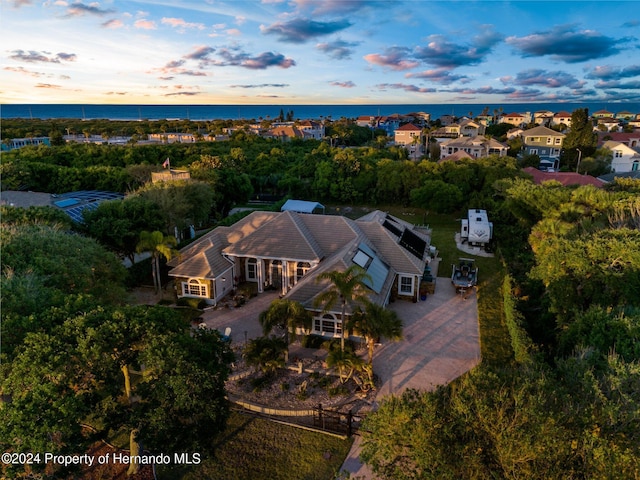 aerial view at dusk featuring a water view