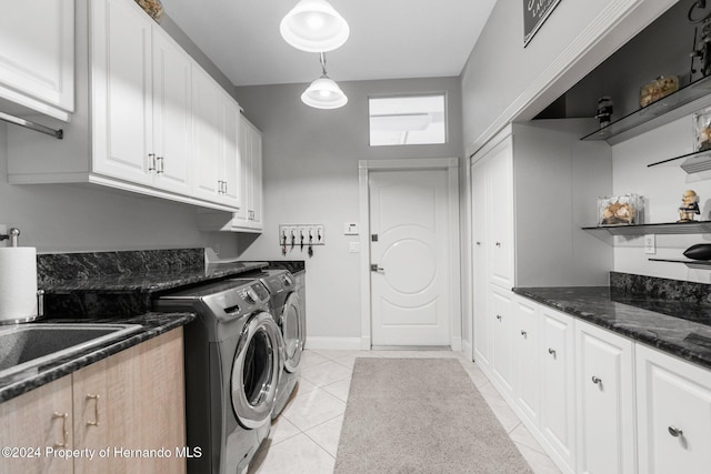 laundry room featuring light tile patterned flooring, cabinets, and independent washer and dryer