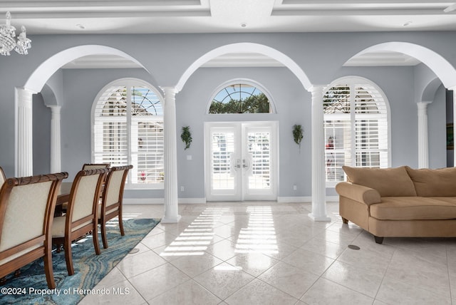 entrance foyer with french doors, light tile patterned floors, and an inviting chandelier