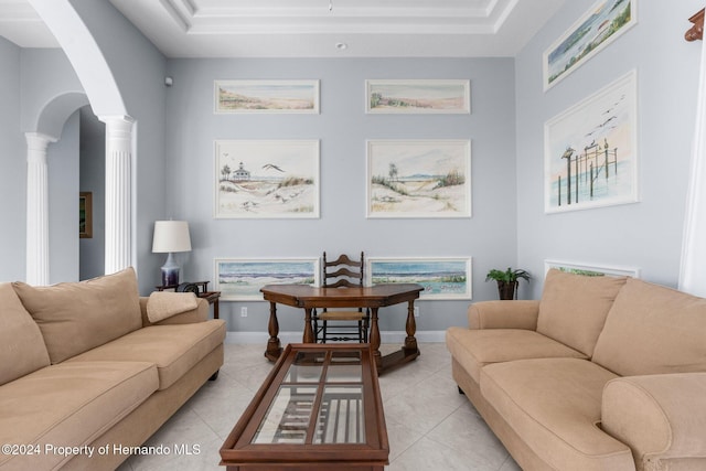 living room with decorative columns, a raised ceiling, and light tile patterned floors