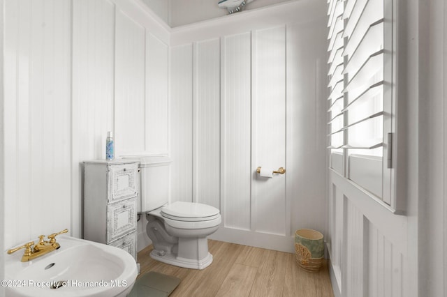 bathroom featuring hardwood / wood-style flooring, toilet, and sink