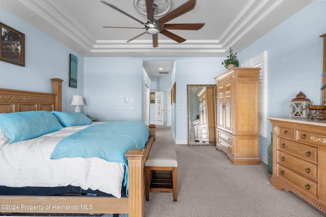 carpeted bedroom with a raised ceiling, ceiling fan, and crown molding