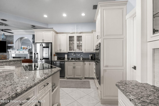 kitchen featuring light stone counters, sink, white cabinets, and stainless steel appliances