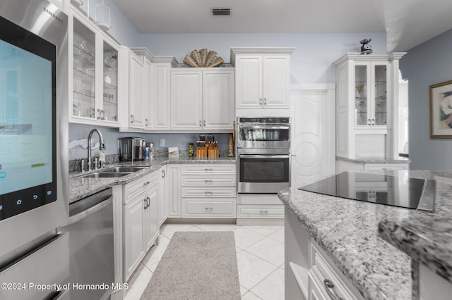 kitchen featuring light tile patterned floors, white cabinetry, sink, and appliances with stainless steel finishes