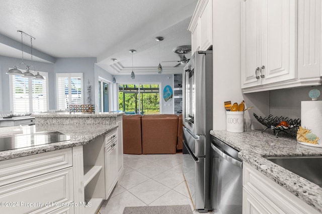 kitchen with white cabinets, decorative light fixtures, stainless steel appliances, and a wealth of natural light