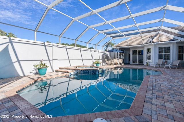 view of pool with an in ground hot tub, a patio, and a lanai