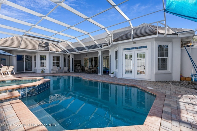 view of pool featuring a patio area, a lanai, an in ground hot tub, and french doors