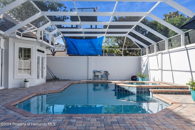 view of pool with a patio area, a lanai, and an in ground hot tub