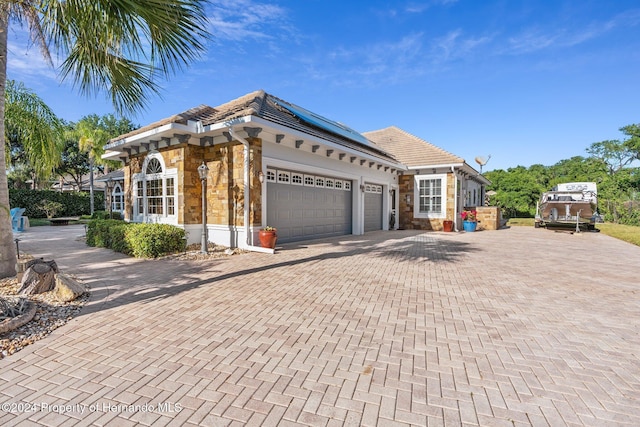 view of front facade featuring solar panels and a garage