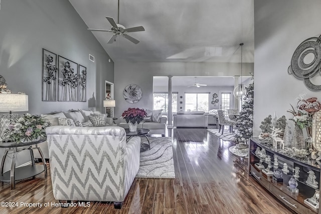 living room with hardwood / wood-style floors, high vaulted ceiling, and ceiling fan with notable chandelier