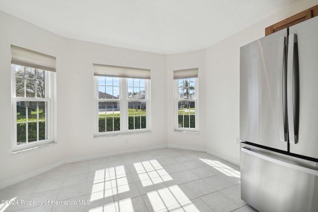 unfurnished dining area featuring light tile patterned floors