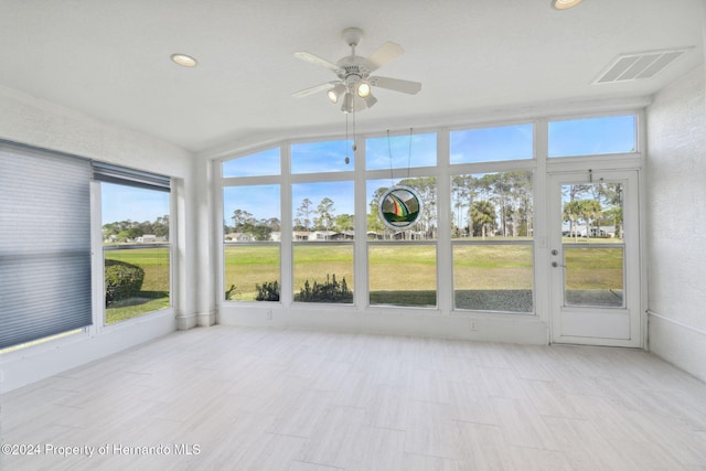 unfurnished sunroom featuring plenty of natural light, ceiling fan, and lofted ceiling