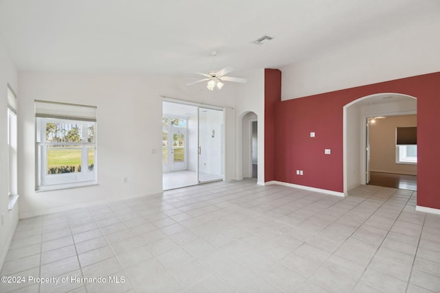 empty room featuring light tile patterned floors, a wealth of natural light, and ceiling fan