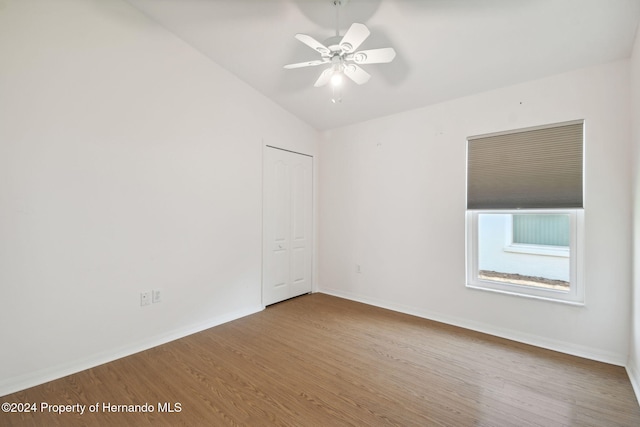 empty room featuring wood-type flooring, vaulted ceiling, and ceiling fan