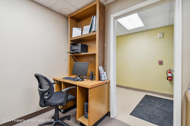 carpeted office space with a drop ceiling