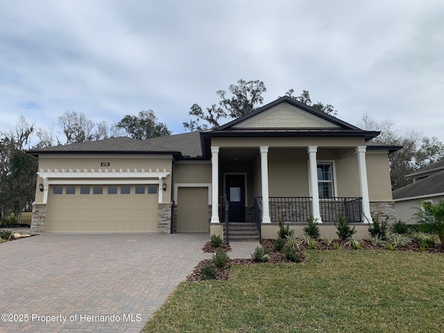 view of front facade featuring a front yard, a garage, and a porch